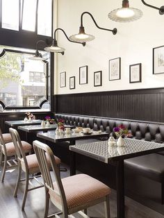 an empty restaurant with black booths and white walls