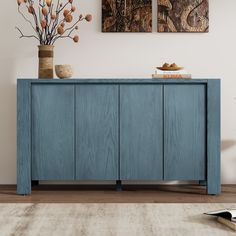 a blue sideboard with two vases on top of it in a living room