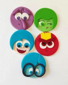 four different faces made out of felt with scissors