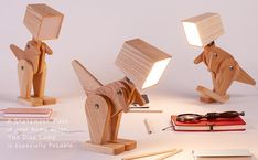 three wooden animals with light bulbs on their heads and one has a book in front of it