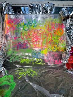 the back of a truck covered in graffiti and aluminum foil with fire hydrants around it