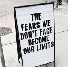 a sign on the sidewalk that says, the fears we don't face become our limits