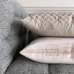 two pillows sitting on top of a gray couch