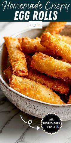 homemade crispy egg rolls in a white bowl on a marble counter with text overlay