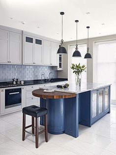 a kitchen with an island and stools in it