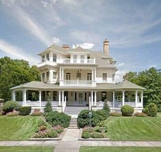 a large white house sitting on top of a lush green field