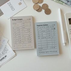 a calculator, pen and some money sitting on top of a white table