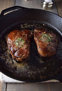 two steaks are cooking in a skillet