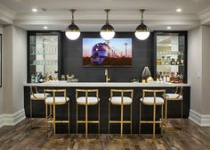 a bar with three stools in front of it and a painting on the wall