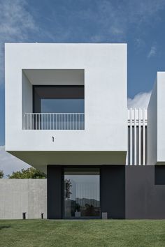 a white and black building with two balconies on the top floor is shown