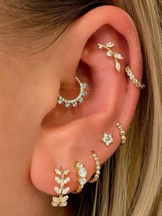 a woman wearing gold ear piercings with crystal stones