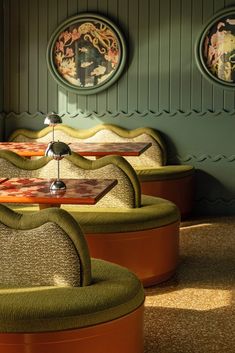 two green couches sitting next to each other on top of a carpeted floor