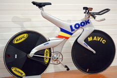 a close up of a bike on display in a room with white walls and wooden floors