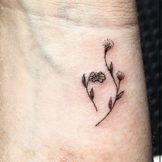 a small flower tattoo on the wrist