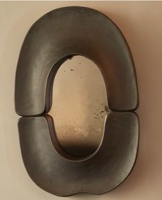 an odd shaped metal object hanging on the wall