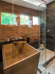 a large wooden bathtub sitting in the middle of a bathroom next to a walk in shower