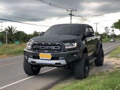 a black truck is parked on the side of the road