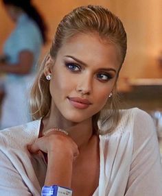 a woman with blonde hair and blue eyes is posing for a photo in white shirt