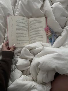 a person laying in bed reading a book