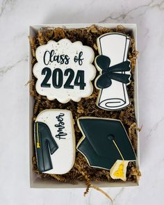 decorated graduation cookies in a box on a table