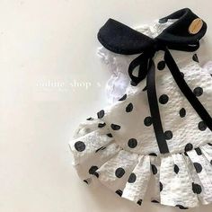 a white and black dress with polka dots on it