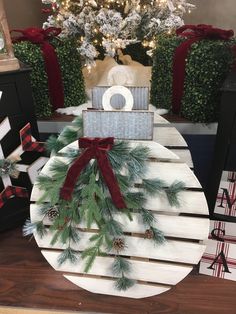 a snowman made out of wooden slats with pine cones and red bows on it