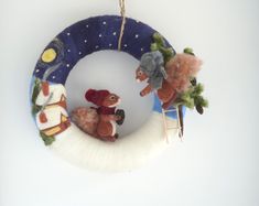 a christmas ornament hanging on a wall with two stuffed animals in the middle