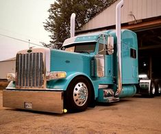 a blue semi truck parked in front of a building