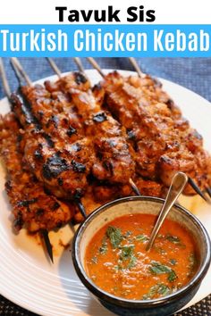 chicken kebabs served on skewers with tomato sauce and garnish