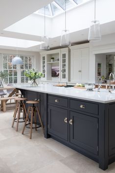 a large kitchen with an island in the middle and two stools next to it