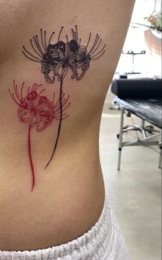 a woman's stomach with a flower tattoo on it