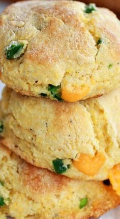 three scones stacked on top of each other with cheese and green leaves in the middle