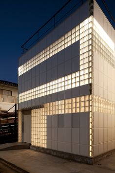 a white building with lots of windows and lights on it's side at night