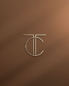 the letter t is inscribed in silver on a brown background