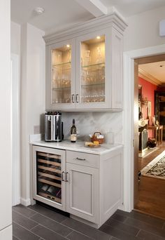 a kitchen with white cabinets and marble counter tops