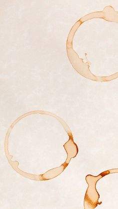 two coffee stains in the shape of rings on a white paper background with brown spots