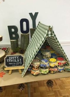 a table topped with lots of different types of crafts and decorations next to a boy sign