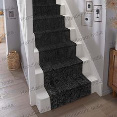 a staircase with black carpet and white handrails