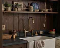 a kitchen with wooden cabinets and black counter tops, an old - fashioned dishwasher is on the wall