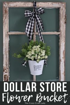 the dollar store flower bucket is hanging on an old window frame with flowers in it