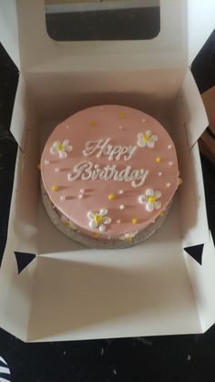 a pink birthday cake in a white box