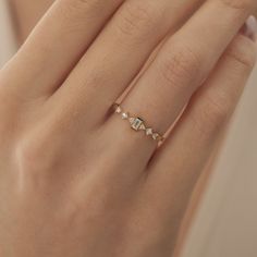 a woman's hand with a gold ring and diamond band on her left hand