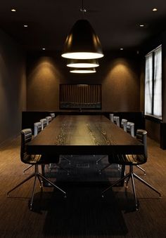 an empty conference room with chairs and a long table in front of two large windows