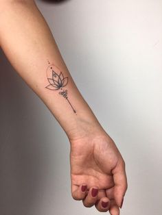 a woman's arm with a small flower tattoo on the left side of her wrist