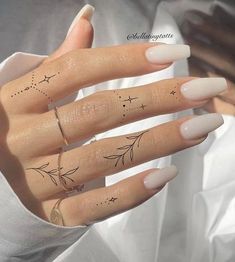 a woman's hand with three finger tattoos on it and two fingers in the shape of stars