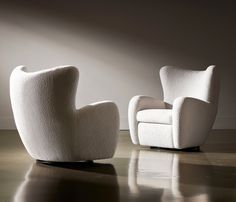 two white chairs sitting next to each other on a floor