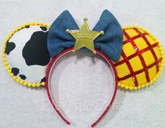 the ears of two mickey mouse ears are decorated with red, yellow and blue fabric