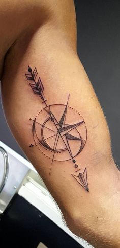 a man's arm with a tattoo on it and an arrow in the middle