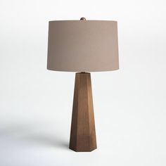 a wooden table lamp with a beige shade