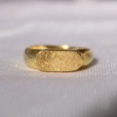 a gold fingerprint ring sitting on top of a table